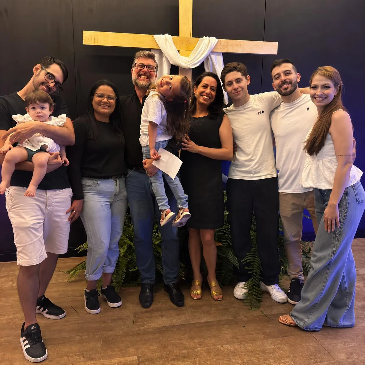 Pr. Daniel Basso com a família diante da cruz, na igreja